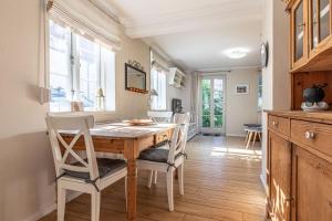 uma sala de jantar com uma mesa de madeira e cadeiras em fewo1846 - Gerty Molzen - komfortable 2-Zimmer-Wohnung mit Terrasse im Stadtzentrum em Flensburg