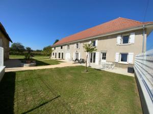 a large building with a yard with a tree at Aux champs Pressinois in Pressins