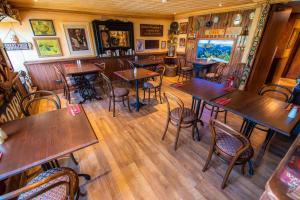a restaurant with wooden tables and chairs in a room at The Rusty Mackerel in Teelin