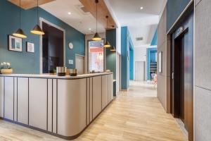 a hallway with a bar with blue walls and wooden floors at Appart'City Confort Paris Clichy - Mairie in Clichy