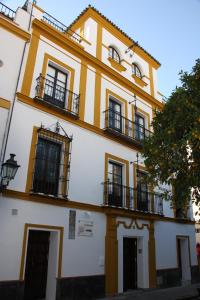 een geel en wit gebouw met ramen en balkons bij Apartamentos en la Plaza Doña Elvira, 7 in Sevilla