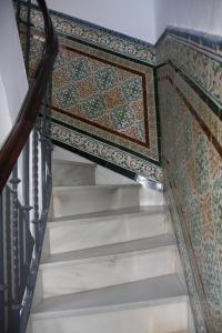 a stairway with a patterned tile on the wall at Apartamentos en la Plaza Doña Elvira, 7 in Seville