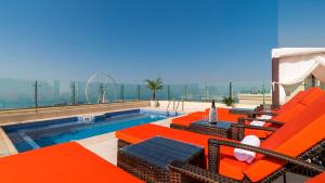 a pool with orange lounge chairs and a swimming pool at Dubai Jbr Amazing Penthouse With Stunning View in Dubai