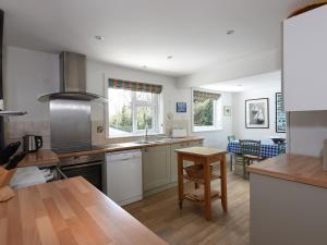 a kitchen with white appliances and a wooden table at Northern Lights in Wadebridge