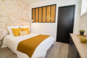 a bedroom with a large bed with yellow pillows at Appartement Cosy Nîmes-Centre in Nîmes