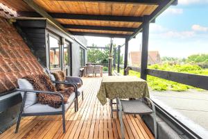 a patio with a table and chairs on a deck at Herberg De Swaen in Vuren