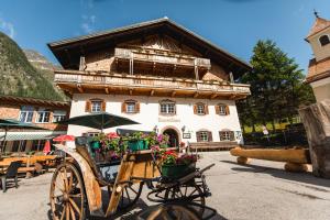 a horse drawn carriage parked in front of a building at Gästehaus Tauernhaus in Matrei in Osttirol