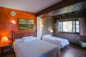 a bedroom with two beds and a window at La Posada de Langre in Langre
