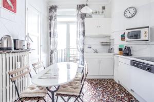 una cucina con tavolo e sedie in una stanza di Charming flat with balcony near Place des Jacobins - Lyon - Welkeys a Lione