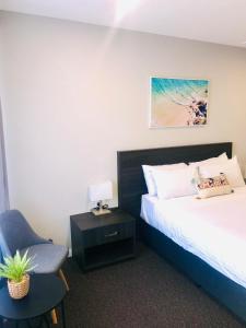 Hive Hotel, Moruya في مورويا: غرفة نوم بسرير وكرسي وطاولة