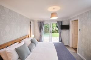 Schlafzimmer mit einem großen weißen Bett und einem Fenster in der Unterkunft Sea Gem- Beautiful family home with stunning sea views & garden in Tenby