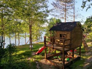 a tree house on the side of a lake at ACTIVFARM DOMKI NA KASZUBACH Domek Piotruś in Gliśno