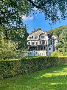 uma casa grande é vista atrás de uma cerca em Villa Gracia em Namur