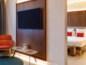 a hotel room with a bed and a tv at Novotel Madrid City Las Ventas in Madrid