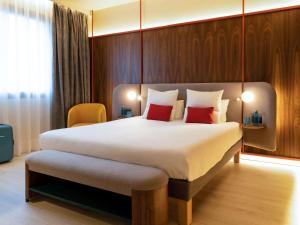 a hotel room with a large bed with red pillows at Novotel Madrid City Las Ventas in Madrid