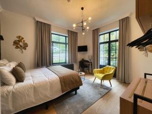 a bedroom with a bed and a desk and some windows at Villa Gracia in Namur