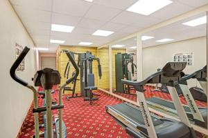 a gym with several treadmills and cardio machines at Days Inn & Suites by Wyndham Louisville SW in Louisville