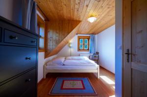 ein Schlafzimmer mit einem Bett und einer Holzdecke in der Unterkunft Lubka Lodge in Lučatín