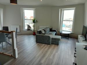 a living room with a couch and a table at Glorious Duplex Holiday Apartment By The Sea in Bognor Regis