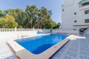 a swimming pool next to a building at Espanatour VIOLETAS in Orihuela