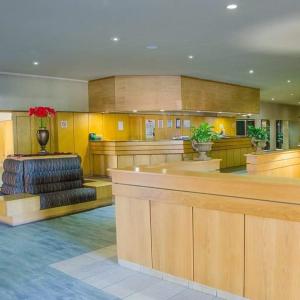 a lobby with a waiting area with chairs and a counter at Midway Inn Hotel in Middelburg