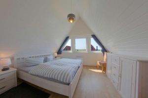 um quarto branco com uma cama num sótão em SR Mellumplate 19 em Dorum Neufeld