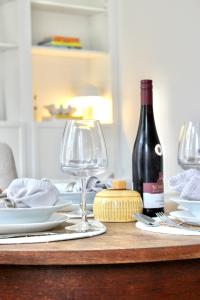 een tafel met een fles wijn en twee wijnglazen bij Apartment Rose in Spirkelbach