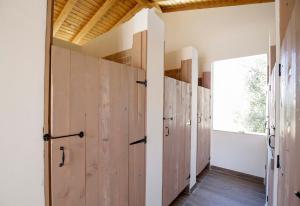 a row of wooden lockers in a room with a window at AGRICAMPEGGIO Agriturismo Passione Natura in Vieste
