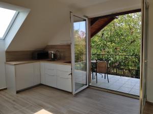 a kitchen with a sliding glass door leading to a balcony at Dali Apartment Szentendre in Szentendre