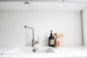 a white kitchen sink with a bottle of wine and a bottle at Apartment Rose in Spirkelbach