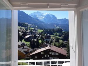 ein Fenster mit Bergblick in der Unterkunft Hotel Regina in Wengen