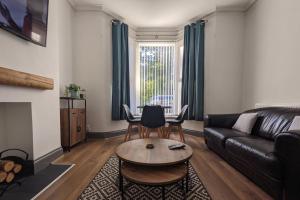 a living room with a leather couch and a table at Linthorpe Terrace in Middlesbrough