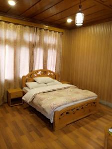 een slaapkamer met een bed met een houten hoofdeinde bij Forest Valley Cottages in Kārandūkai