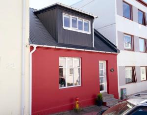 una casa roja con techo negro en Moon Apartments, en Reikiavik