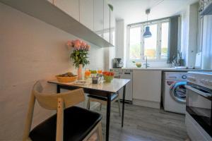 una cocina con una mesa con un jarrón de flores. en Sanders Lake - Pleasant Two-Bedroom Apartment in Downtown Copenhagen, en Copenhague