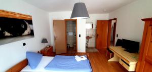 a small bedroom with a blue bed and a desk at Grüner Baum in Neckargerach