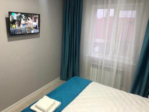 sypialnia z łóżkiem i oknem z telewizorem w obiekcie HANYM HOTEL w mieście Atyrau