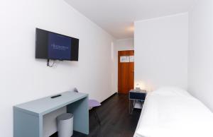 a bedroom with a bed and a tv on a wall at Die Schlafbude in Wesseling