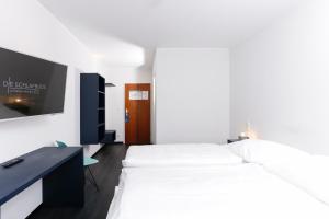 韋瑟靈的住宿－Die Schlafbude，一间卧室配有一张床、一张书桌和一台电视。