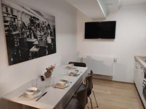 a dining room with a table with chairs and a tv at Apartment "Marie" in ehemaliger Schuhfabrik in Herxheim