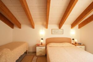 two beds in a room with wooden ceilings at Appartamenti In Piazzetta in Deiva Marina +109 photos