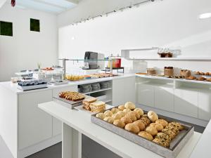uma grande cozinha branca com muitos tipos diferentes de pastelarias em Art Hotel Principe em Lignano Sabbiadoro