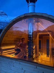 a man and a woman sitting in a sauna at North Experience Basecamp in Melen