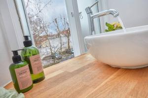 ein Badezimmer mit einem Waschbecken und einer Theke mit zwei Flaschen in der Unterkunft Central Lyngby Apartments in Kongens Lyngby