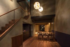 a dining room with a table and a staircase at Masarigusa Machiya House in Kyoto