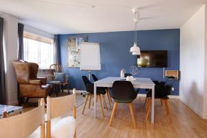 勒茲維的住宿－Kridthuset，一间拥有蓝色墙壁和桌椅的用餐室