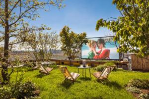 un jardín con sillas y una pantalla con una película en Hotel Paradiso, en París