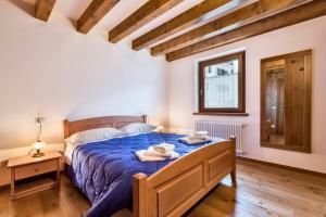 una camera da letto con un letto blu e asciugamani di Albergo Diffuso Sutrio Zoncolan a Sùtrio