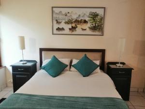 a bedroom with a bed with two night stands and two lamps at San Lameer Villa 2026 in Southbroom