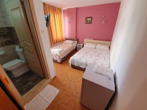 a small room with two beds and a bathroom at Ozge Pansiyon in Didim